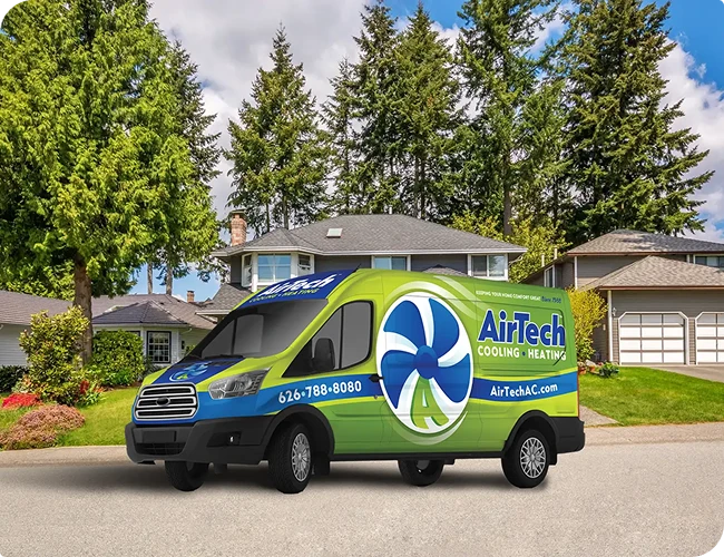 A green and blue AirTech Cooling and Heating service van parked on a suburban street in front of houses and trees.
